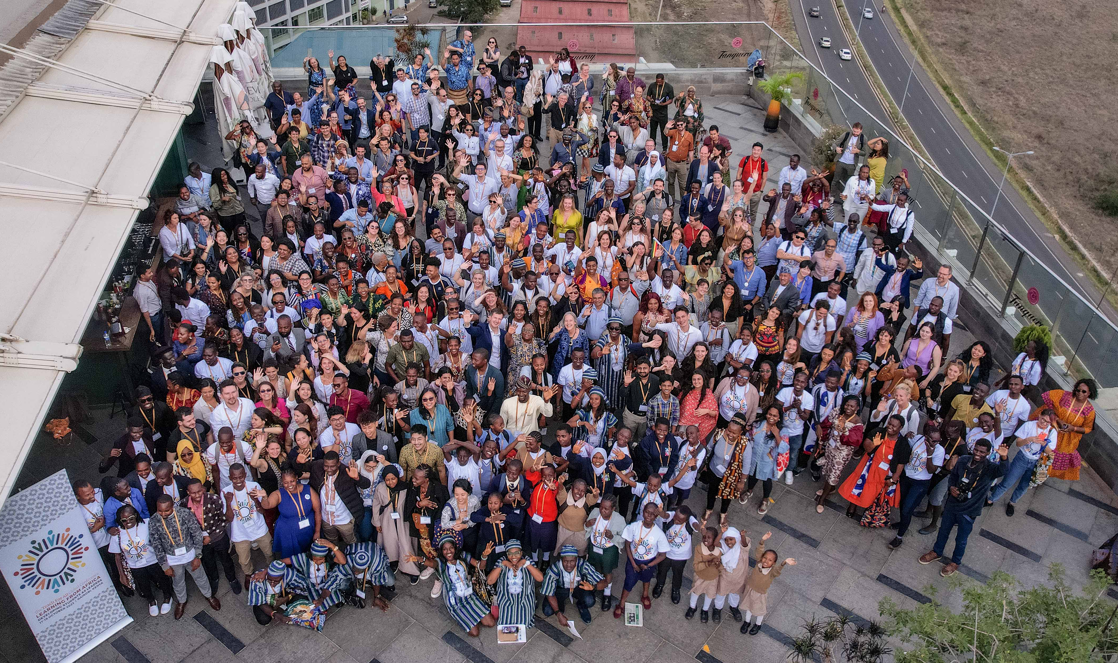 An overhead shot of a large, diverse group of people on a roof