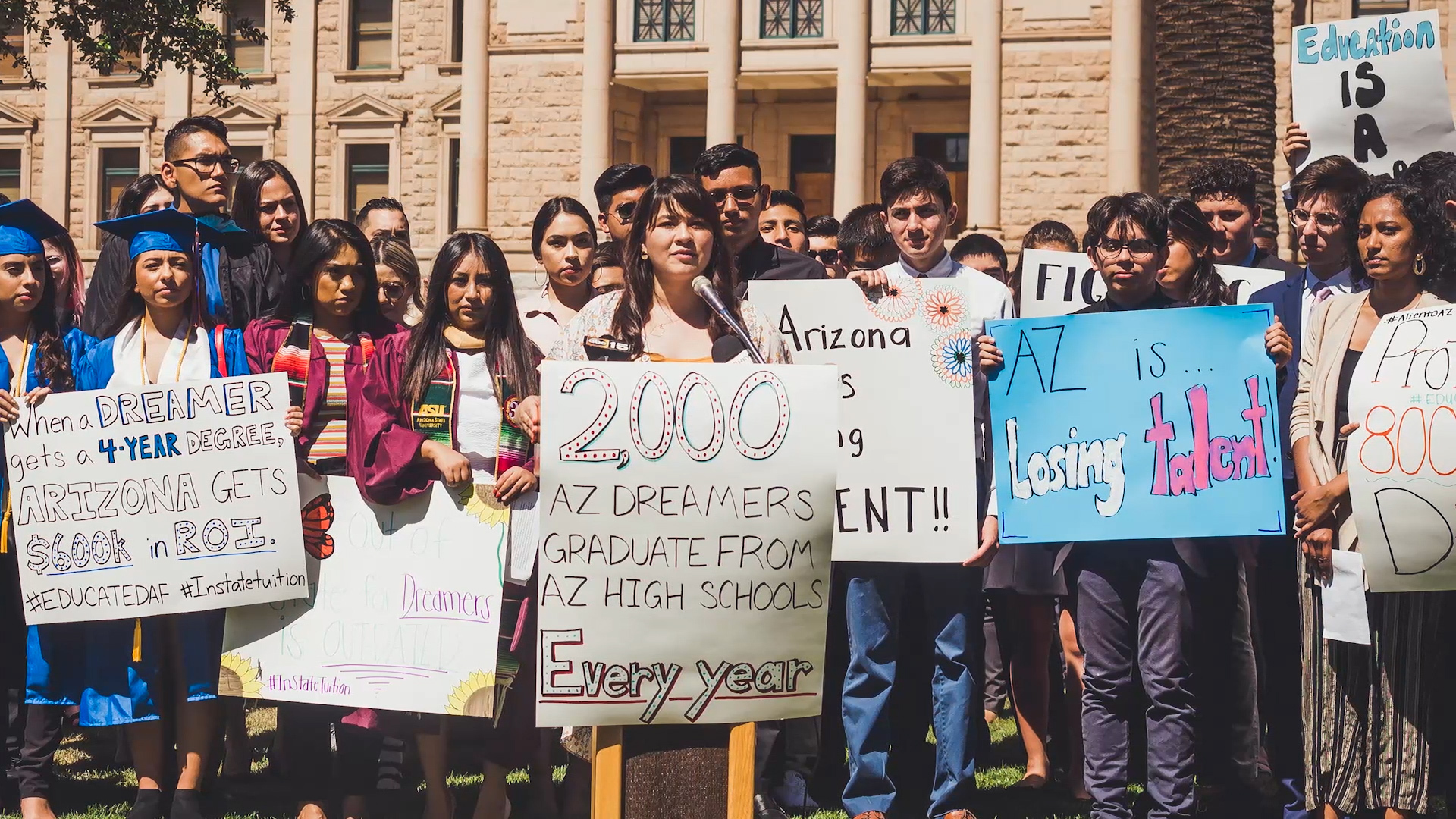 A group of young people hold up signs advocating for the rights of undocumented people in the US